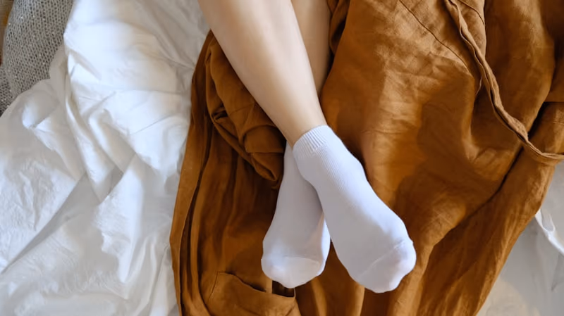 Dámské slabé bílé kotníkové ponožky na posteli
